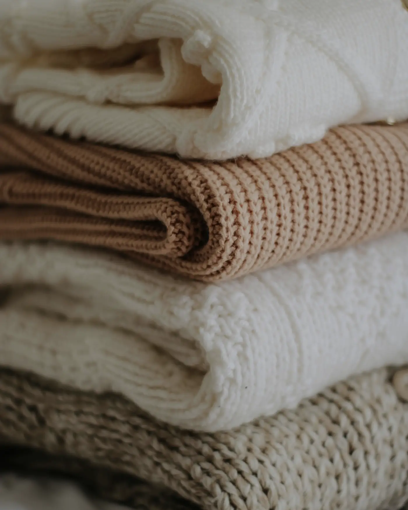 Folded wool and cashmere knitwear in warm neutral tones